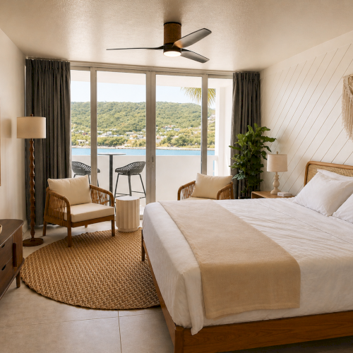 A bright modern bedroom with a large bed, rattan furniture, lamps, dark curtains, a ceiling fan, and big windows overlooking hills and a lake.